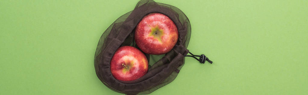 top view of red ripe apples in eco friendly bag isolated on green, panoramic shot - Photo, Image
