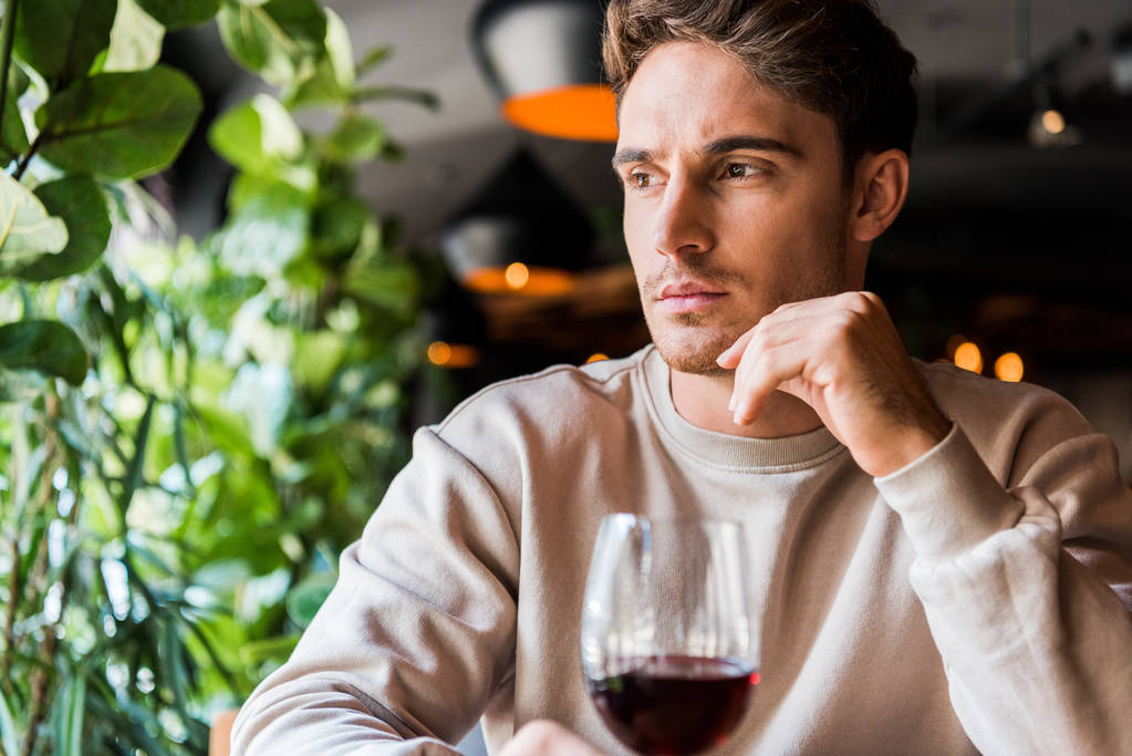 enfoque selectivo del hombre sentado en el restaurante con copa de vino tinto
  - Foto, Imagen