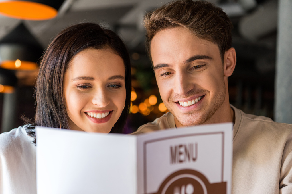 вибірковий фокус щасливого чоловіка і весела жінка тримає меню
  - Фото, зображення
