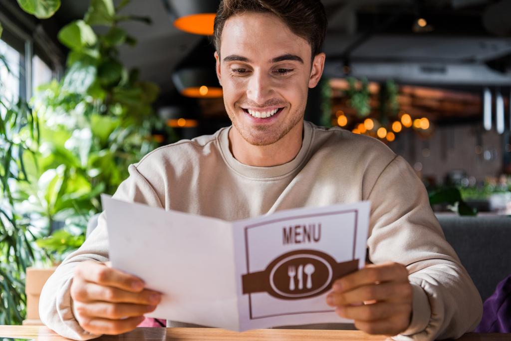 foyer sélectif de l'homme heureux en regardant le menu au restaurant
  - Photo, image