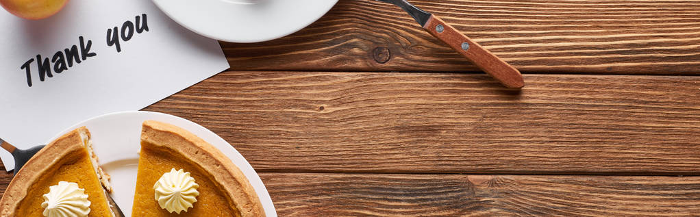 vista superior da torta de abóbora e cartão de agradecimento na mesa marrom de madeira, tiro panorâmico
 - Foto, Imagem