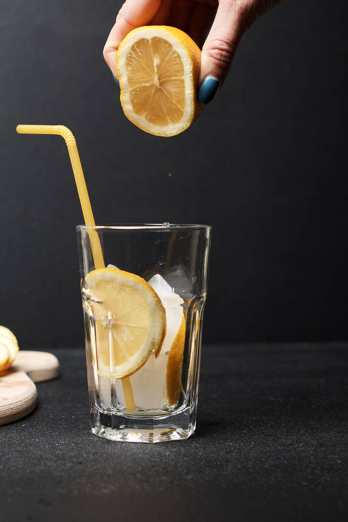 limonu bardağın üzerinde yarı yarıya tutarak yaz taze kokteyli, yakın görüş - Fotoğraf, Görsel