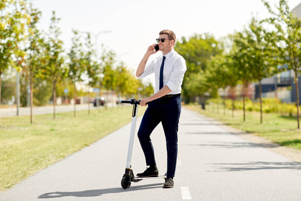 homem de negócios com scooter chamando no smartphone
 - Foto, Imagem