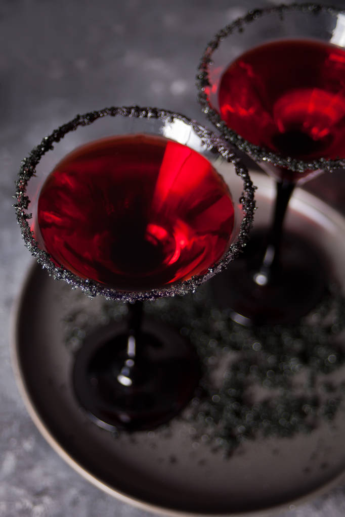 Két pohár vörös koktéllal a Halloween party a sötét háttér - Fotó, kép