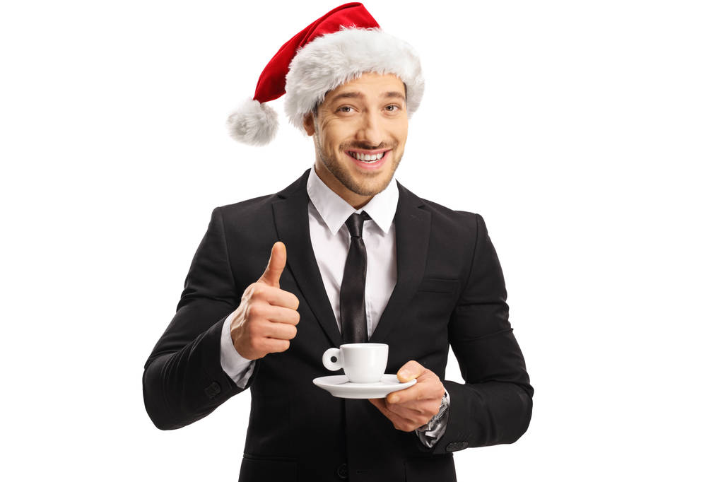 Empresario con un sombrero de Santa Claus sosteniendo una taza de café espresso
 - Foto, Imagen