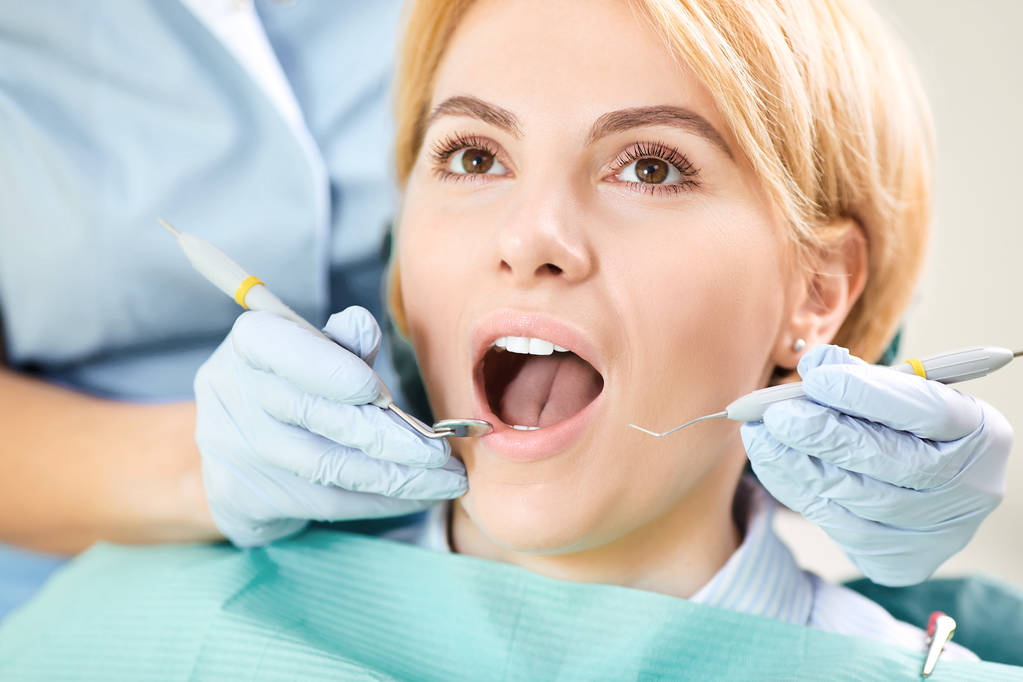 Tandarts controleert de tanden van een meisje - Foto, afbeelding