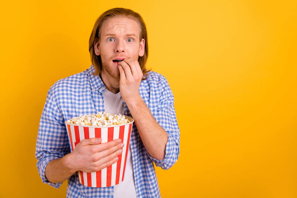 Φωτογραφία του τρομοκρατημένο άφωνο φοβισμένος αναπαυμένο άνθρωπος σε πανικό ενώ βλέποντας ταινία τρόμου στο σινεμά με άδειο χώρο δίπλα του απομονώνεται πάνω από κίτρινο ζωντανό φόντο χρώμα - Φωτογραφία, εικόνα