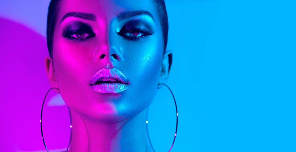 Mode-Modell brünette Frau in bunten hellen Neonlichtern posiert im Studio. trendy leuchtendes Make-up, metallische silberne Lippen. - Foto, Bild