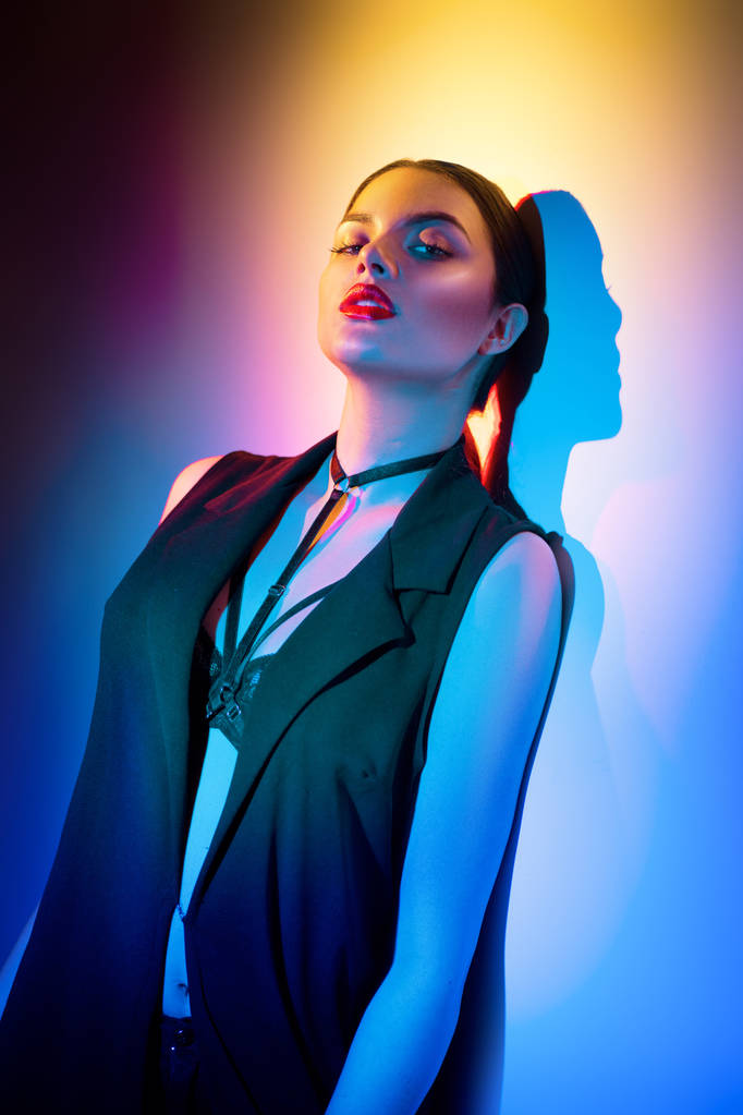 Sexy menina morena em roupas pretas, acessórios de moda posando em estúdio sobre fundo colorido
 - Foto, Imagem