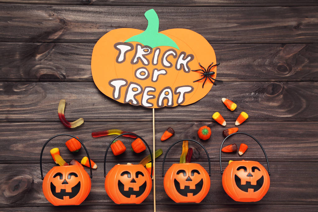Text Trick or Treat with pumpkin buckets and candies on wooden b - Photo, Image
