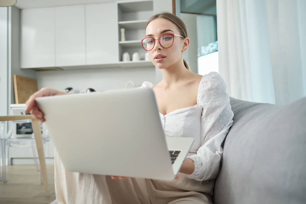 Piękna młoda uśmiechnięta kobieta pracuje na laptopie w domu - Zdjęcie, obraz
