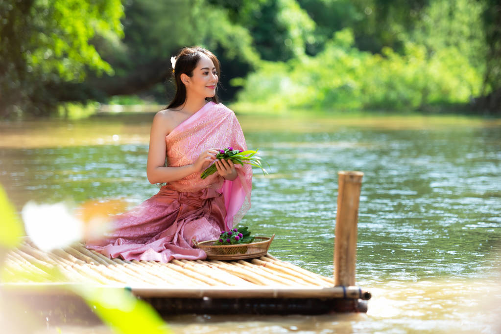 Traditional asian woman Thai dress sitting and relax in wood bridge nature river.  Thailand - Photo, Image