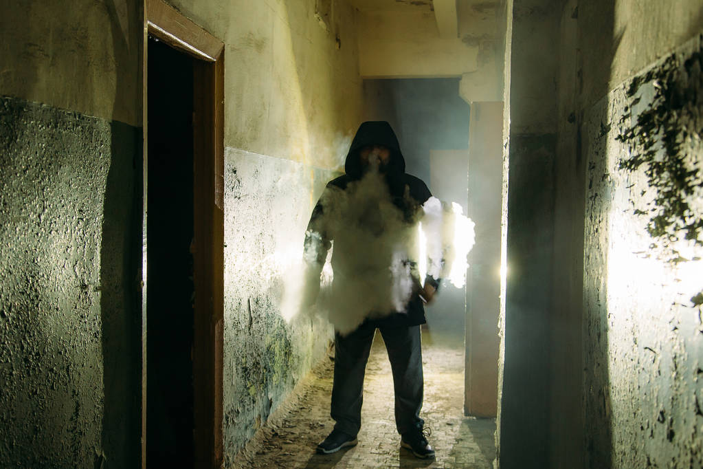 Силуэт дымящегося человека в темном мрачном коридоре
  - Фото, изображение