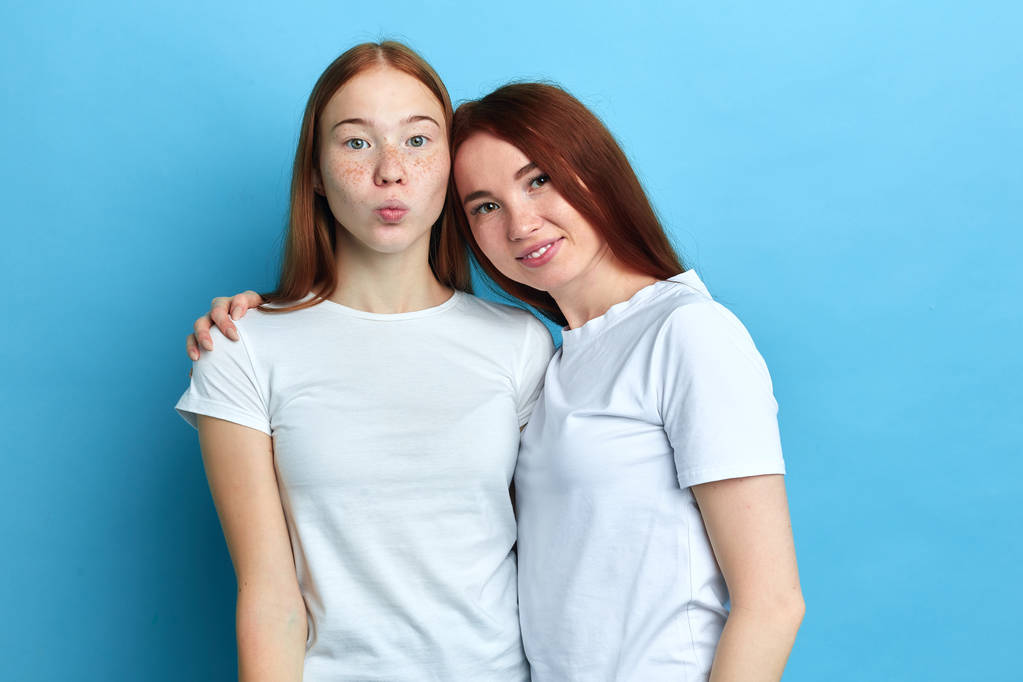 δύο φοβερές αδελφές φορώντας άσπρα μπλουζάκια κοιτάζοντας την κάμερα - Φωτογραφία, εικόνα