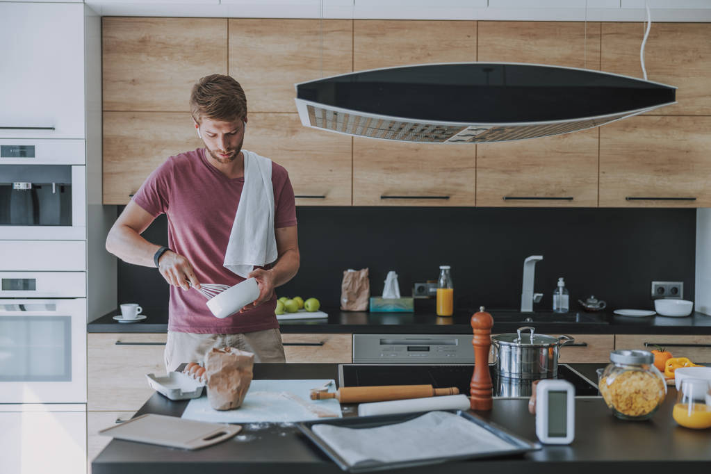 Cocinero concentrado haciendo comida en su cocina
 - Foto, imagen