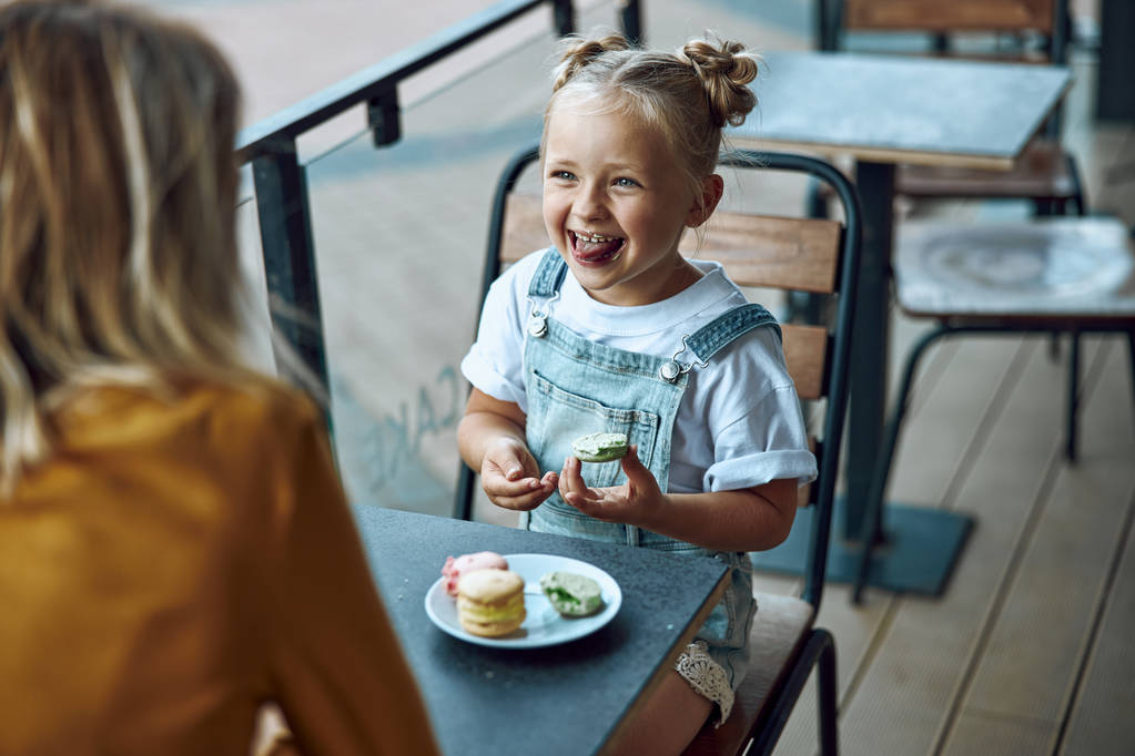 Menina engraçada comer biscoito e sorrindo foto stock
 - Foto, Imagem