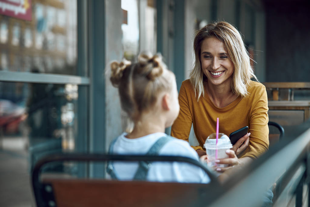 Mujer alegre en la cafetería con hija stock foto
 - Foto, Imagen