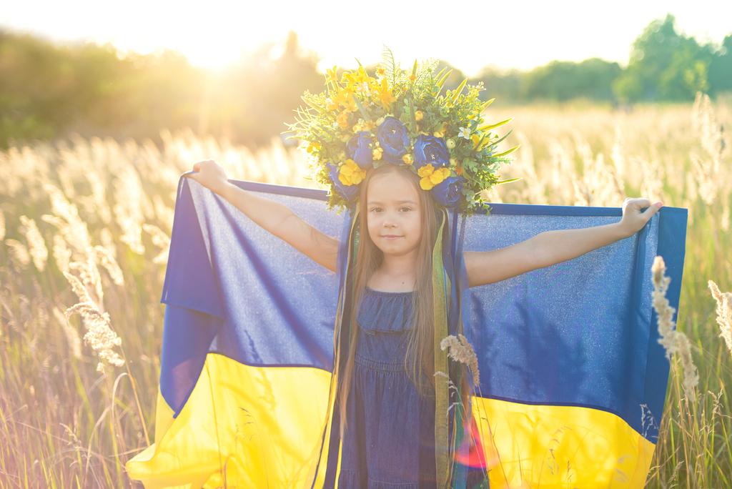 Chica lleva ondeando bandera azul y amarillo de Ucrania en el campo
. - Foto, imagen