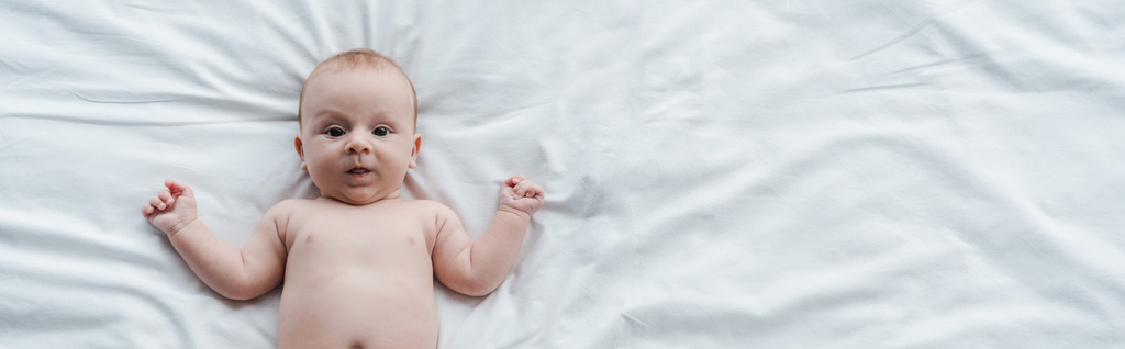 Evde yatakta uzanmış sevimli bebeğin panoramik görüntüsü.  - Fotoğraf, Görsel