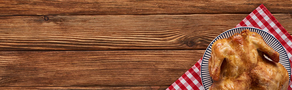 πάνω όψη της ψητής γαλοπούλας σε κόκκινη καρό πετσέτα σερβιρισμένη σε ξύλινο τραπέζι, πανοραμική λήψη - Φωτογραφία, εικόνα