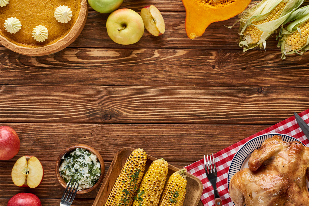 вид сверху на жареную индейку, тыквенный пирог и овощи на гриле, подаваемые на деревянном столе
 - Фото, изображение