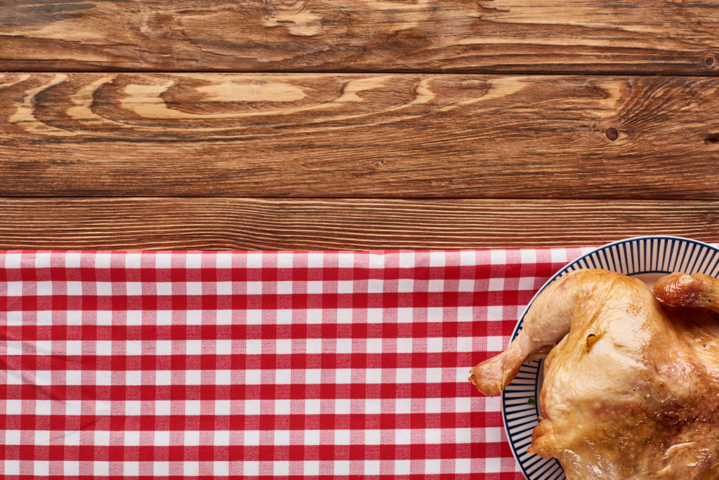 vista superior del pavo asado servido en servilleta a cuadros roja en la mesa de madera para la cena de Acción de Gracias
 - Foto, imagen