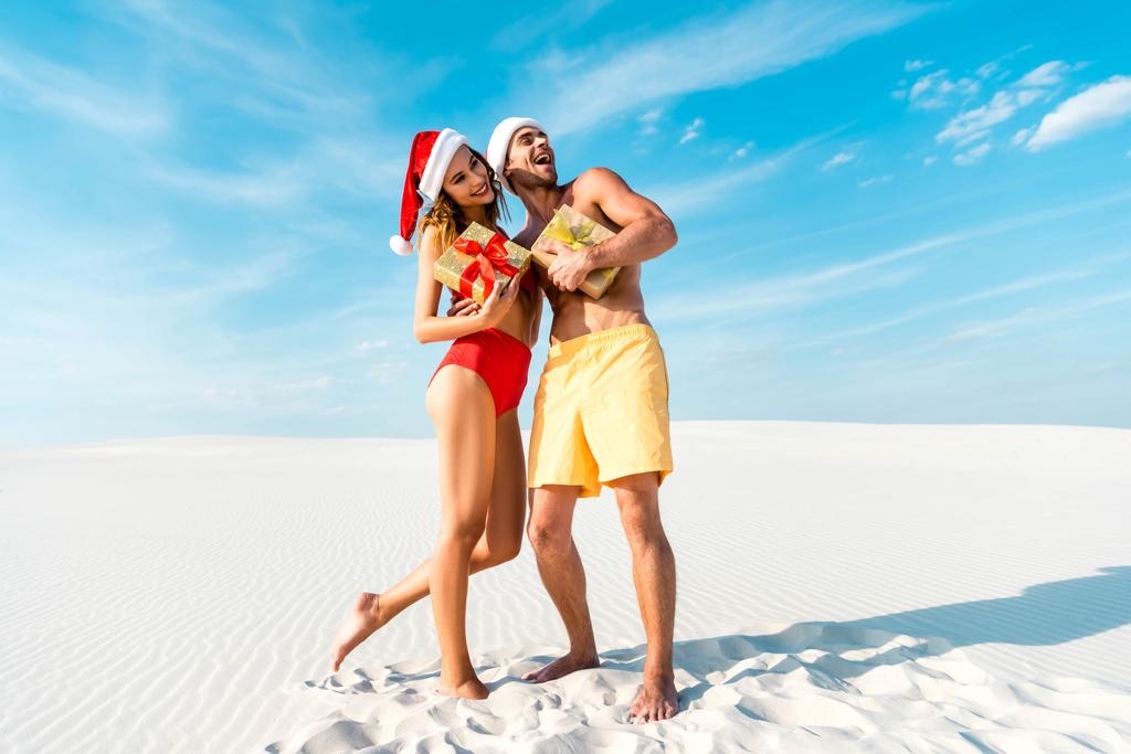 sexy a usmívající se přítelkyně a přítel držící dárky na pláži na Maledivách  - Fotografie, Obrázek
