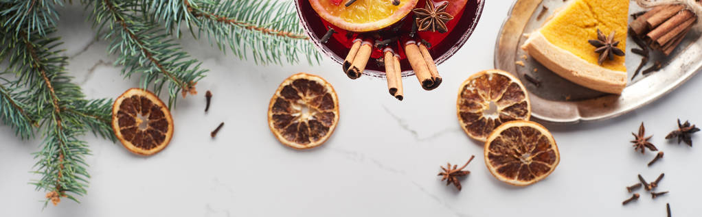 plano panorámico de cóctel de Navidad con naranja, granada, canela y pastel en bandeja
  - Foto, Imagen