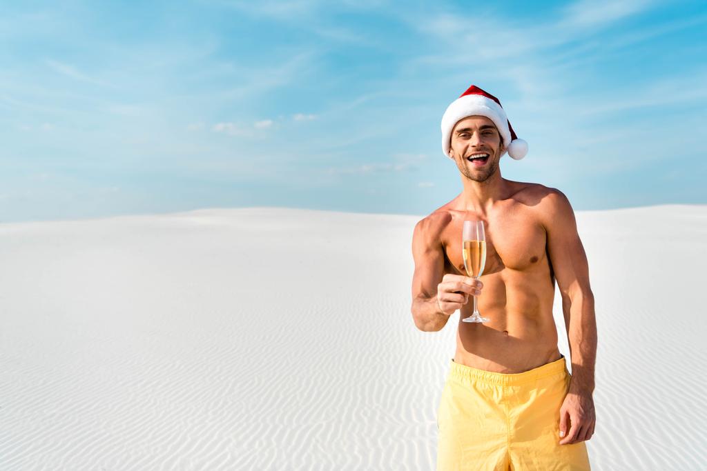 Noel Baba şapkalı seksi adam Maldivler sahilinde şampanya bardağı tutuyor.  - Fotoğraf, Görsel