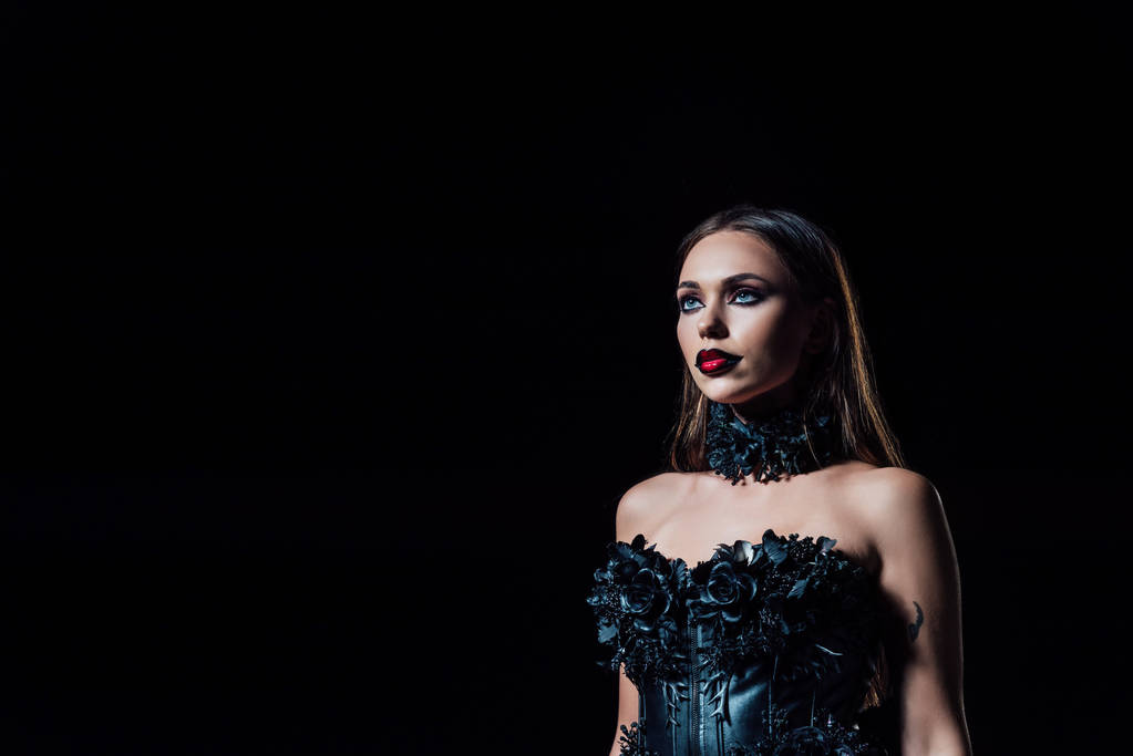 espeluznante chica vampiro en vestido gótico negro mirando hacia otro lado aislado en negro
 - Foto, imagen