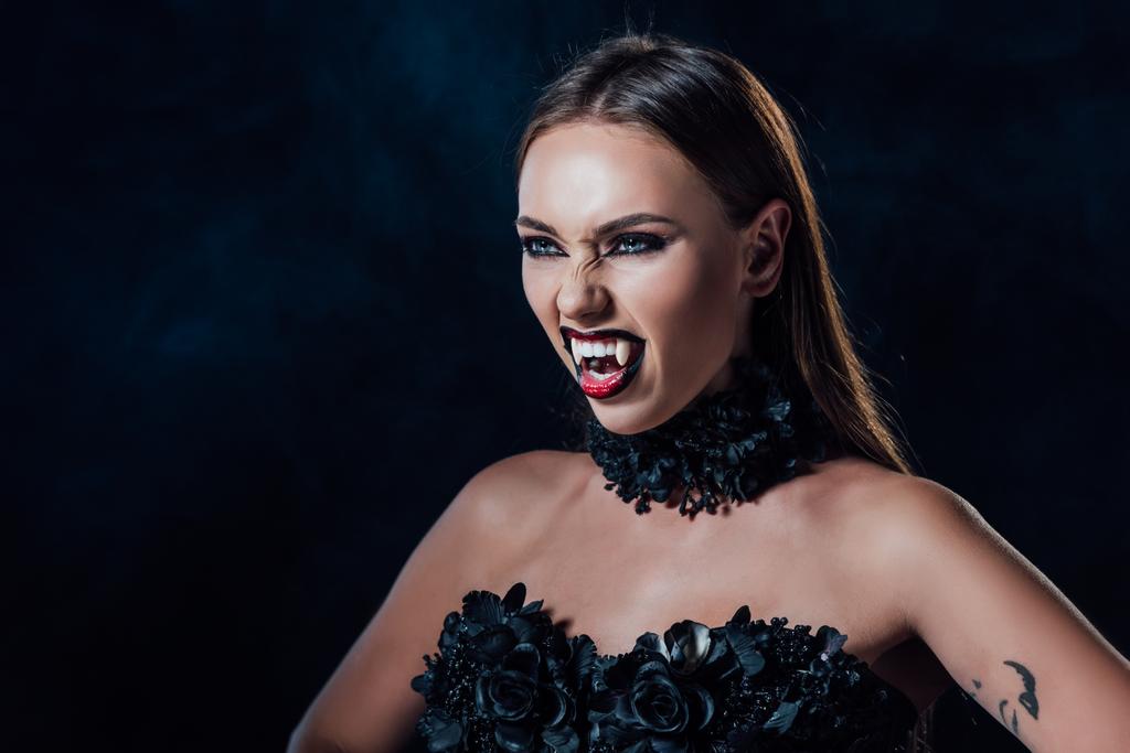 assustador vampiro menina com presas em preto vestido gótico isolado no preto
 - Foto, Imagem