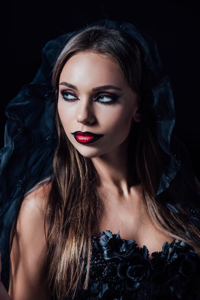 espeluznante chica vampiro en vestido gótico negro y velo mirando hacia otro lado aislado en negro
 - Foto, imagen