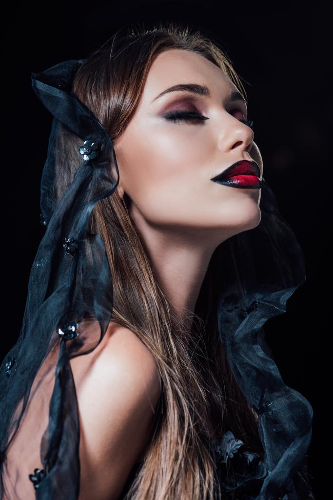 scary vampire girl with closed eyes in black gothic dress and veil isolated on black - Photo, Image