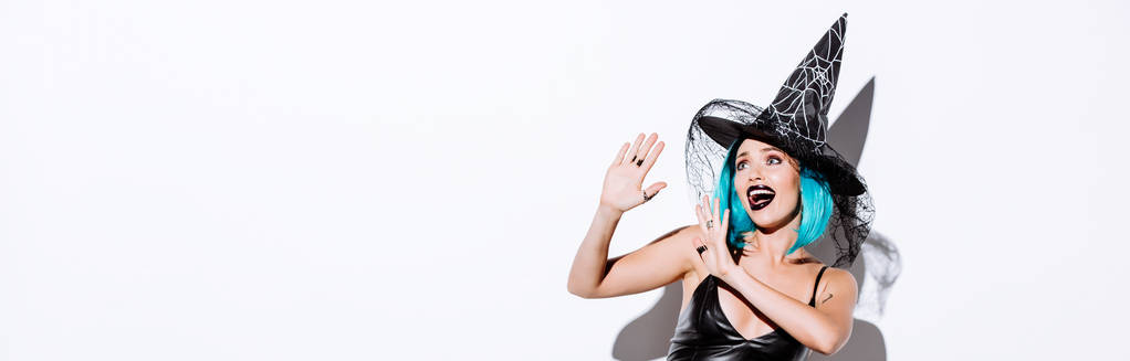 colpo panoramico di ragazza in costume nero strega Halloween con i capelli blu su sfondo bianco
 - Foto, immagini