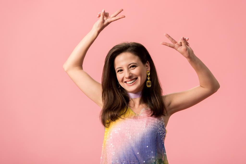 felice giovane ragazza discoteca elegante mostrando segno di pace isolato su rosa
 - Foto, immagini