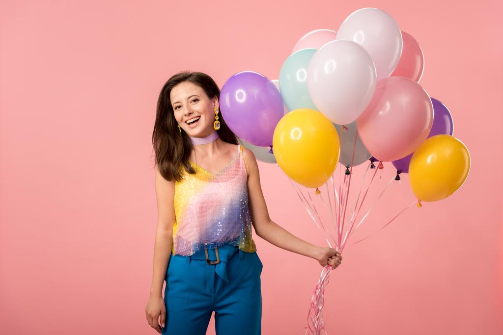 young happy party girl holding festive balloons isolated on pink - 写真・画像