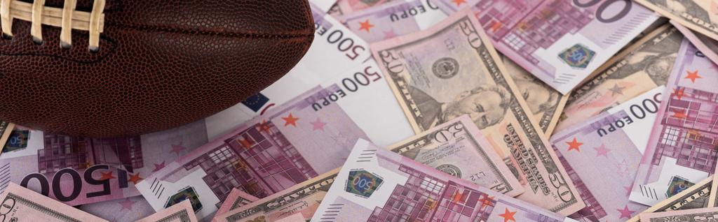 colpo panoramico di pallone da rugby su banconote in euro e dollari, concetto di scommesse sportive
 - Foto, immagini
