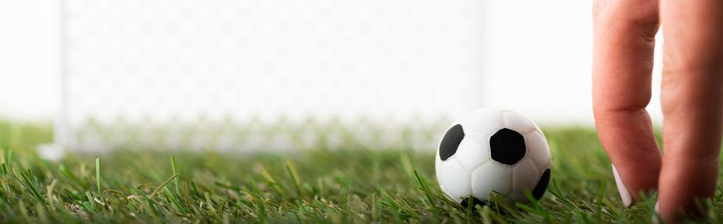 abgeschnittene Ansicht weiblicher Finger in der Nähe von Spielzeug-Fußballball und Fußballtoren isoliert auf weißem, Sportwetten-Konzept - Foto, Bild