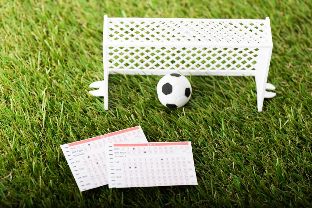 Spielzeugfußballtore, Ball und Wettlisten auf grünem Rasen, Sportwetten-Konzept - Foto, Bild