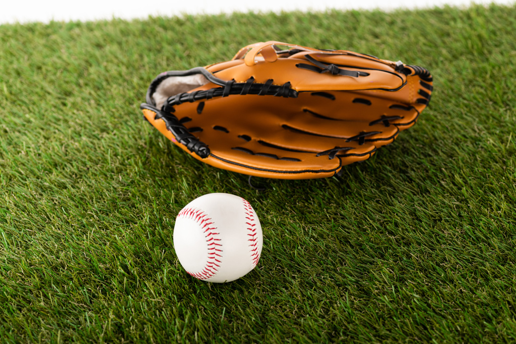 baseball kesztyű és labda zöld füvön elszigetelt fehér, sportfogadás koncepció - Fotó, kép
