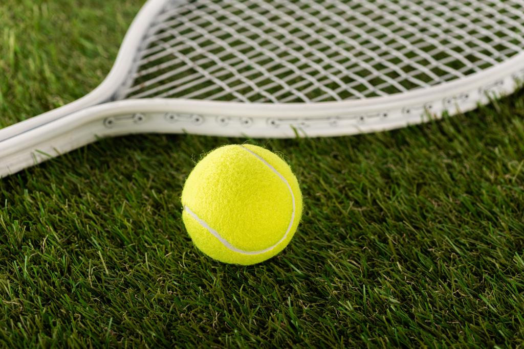 Tenis raketi ve top yeşil çimlerde, spor bahisleri konsepti - Fotoğraf, Görsel