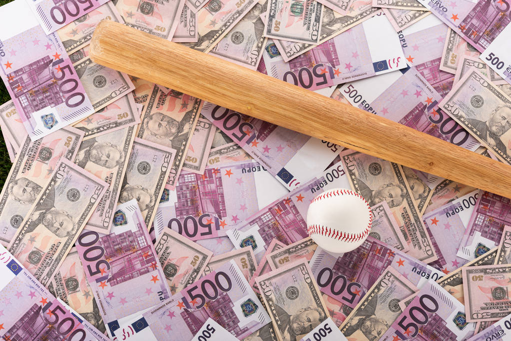 widok z góry kij baseballowy i piłka na banknotach euro i dolara, koncepcja zakładów sportowych - Zdjęcie, obraz