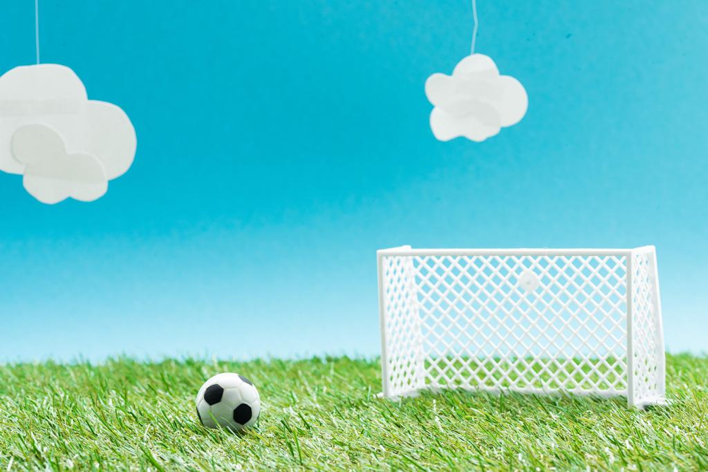 ミニチュアサッカーボールと雲 スポーツの賭けの概念と青の背景の門を持つサッカー場 ロイヤリティフリー写真 画像素材