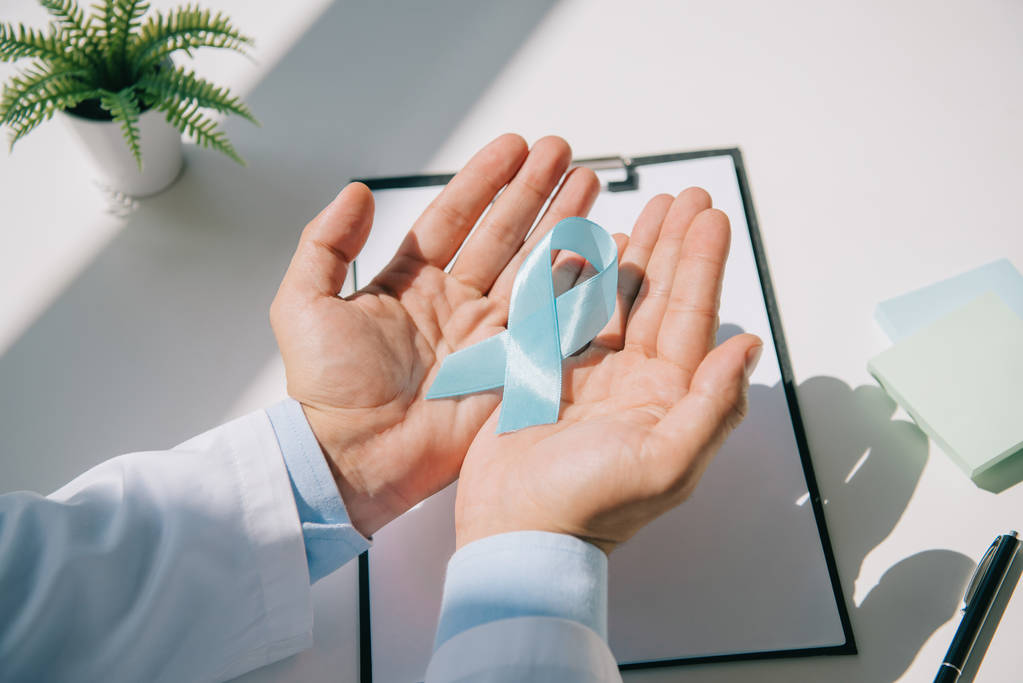 Ausgeschnittene Ansicht eines Arztes mit blauem Band in der Nähe des Klemmbretts  - Foto, Bild