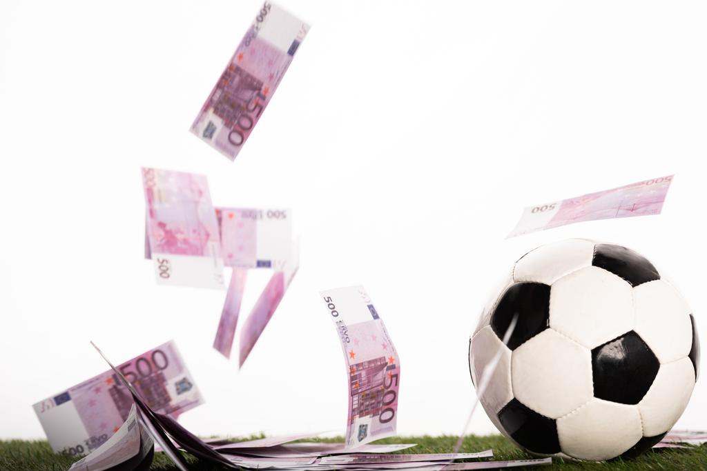 voetbal in de buurt van vliegende eurobankbiljetten geïsoleerd op wit, sportweddenschappen concept - Foto, afbeelding