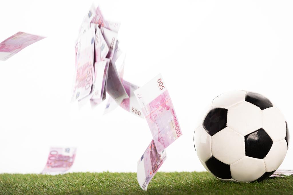 Футбольный мяч рядом с летающими банкнотами евро изолирован на белом, концепция ставок на спорт
 - Фото, изображение