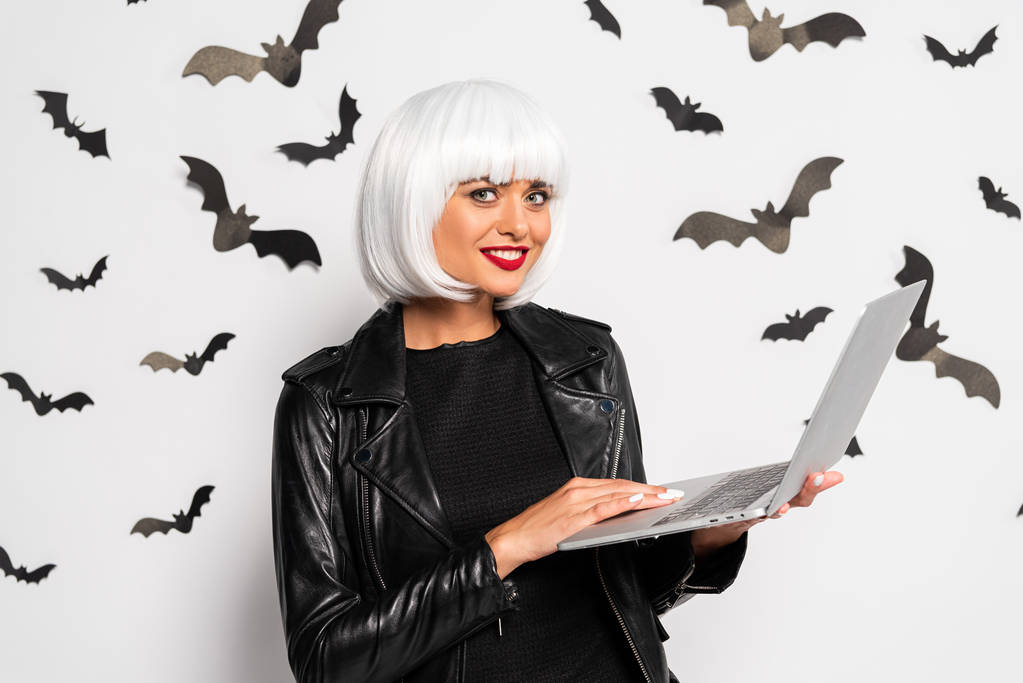 привлекательная женщина в белом парике держит ноутбук в Хэллоуин
 - Фото, изображение