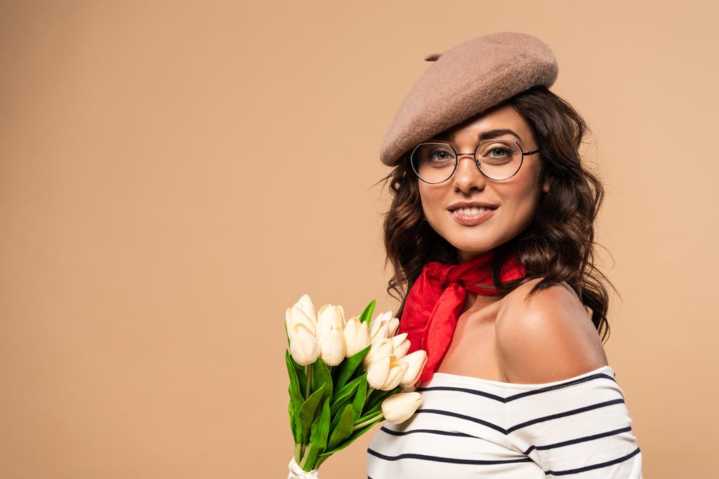 フランス人女性でベレー帽保持花束オンベージュ背景  - 写真・画像