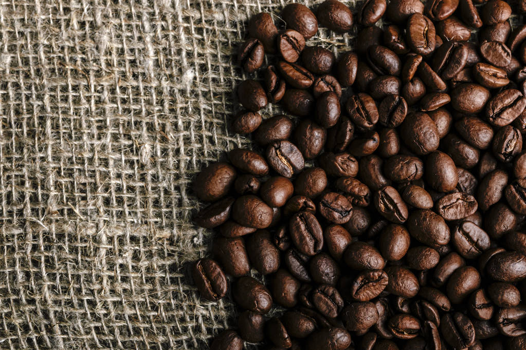 Granos de café sobre fondo de arpillera - Foto, Imagen