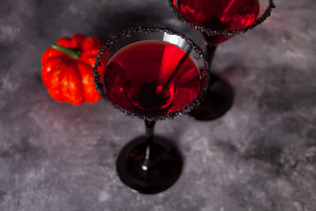 Dvě skleničky s červeným koktejlem, dýně na Halloweenský večírek na tmavém pozadí - Fotografie, Obrázek